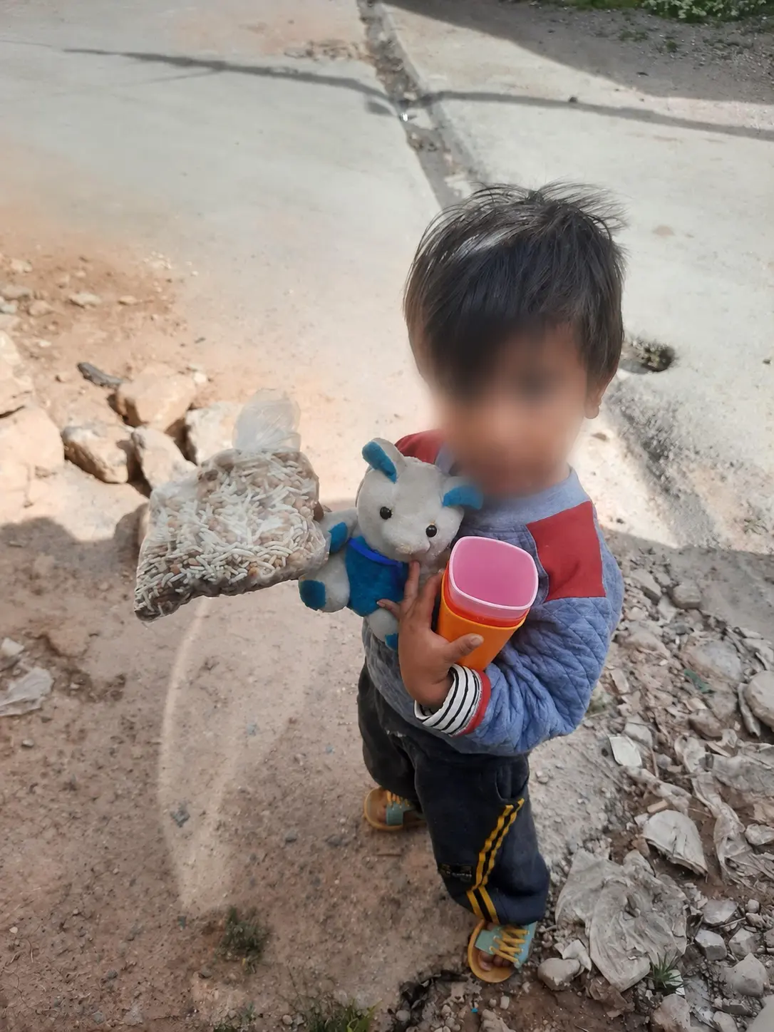 A child holding a bag of supplies from the delivery