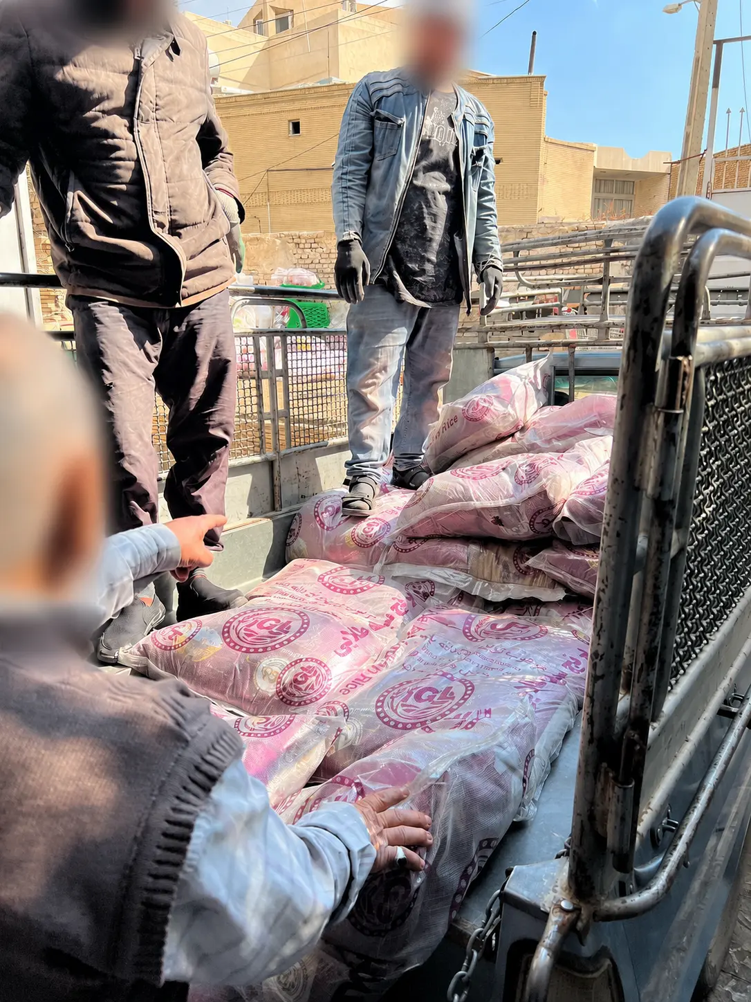 Volunteers loading rice and supplies onto a delivery vehicle